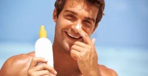 This image is about man applying sunscreen on face