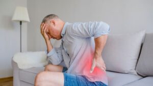 Person suffering from back pain and headache